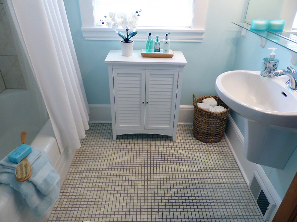 Inredning av ett amerikanskt litet en-suite badrum, med möbel-liknande, vita skåp, ett badkar i en alkov, en dusch/badkar-kombination, en toalettstol med separat cisternkåpa, flerfärgad kakel, keramikplattor, blå väggar, klinkergolv i keramik, ett väggmonterat handfat, flerfärgat golv och dusch med duschdraperi