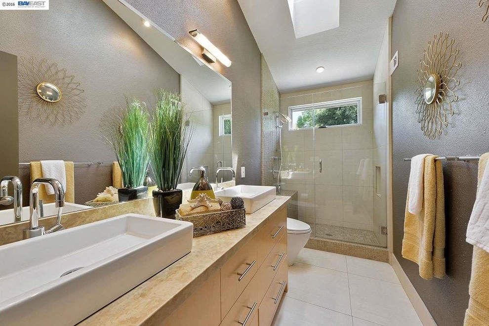 Modelo de cuarto de baño contemporáneo de tamaño medio con armarios con paneles lisos, puertas de armario de madera clara, ducha empotrada, paredes marrones, aseo y ducha y lavabo sobreencimera