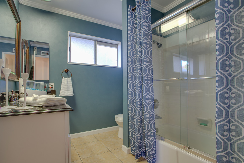 Aménagement d'une petite salle de bain classique pour enfant avec un placard avec porte à panneau encastré, des portes de placard blanches, une baignoire posée, un combiné douche/baignoire, WC séparés, un carrelage beige, des carreaux de céramique, un mur bleu, un sol en carrelage de céramique et un plan de toilette en granite.