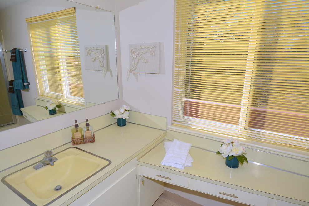 Bild på ett mellanstort 50 tals en-suite badrum, med ett nedsänkt handfat, släta luckor, vita skåp, en toalettstol med separat cisternkåpa, beige kakel, vita väggar och linoleumgolv