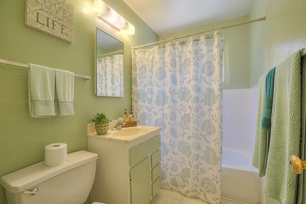 Exempel på ett litet klassiskt badrum för barn, med ett integrerad handfat, släta luckor, vita skåp, bänkskiva i akrylsten, ett hörnbadkar, en dusch/badkar-kombination, en toalettstol med separat cisternkåpa, vit kakel, keramikplattor, gröna väggar och linoleumgolv