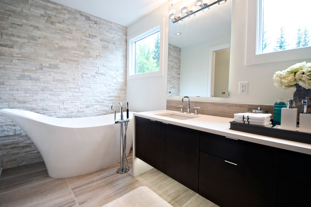 Idéer för funkis en-suite badrum, med ett undermonterad handfat, släta luckor, skåp i mörkt trä, ett fristående badkar, stenkakel, vita väggar och marmorgolv