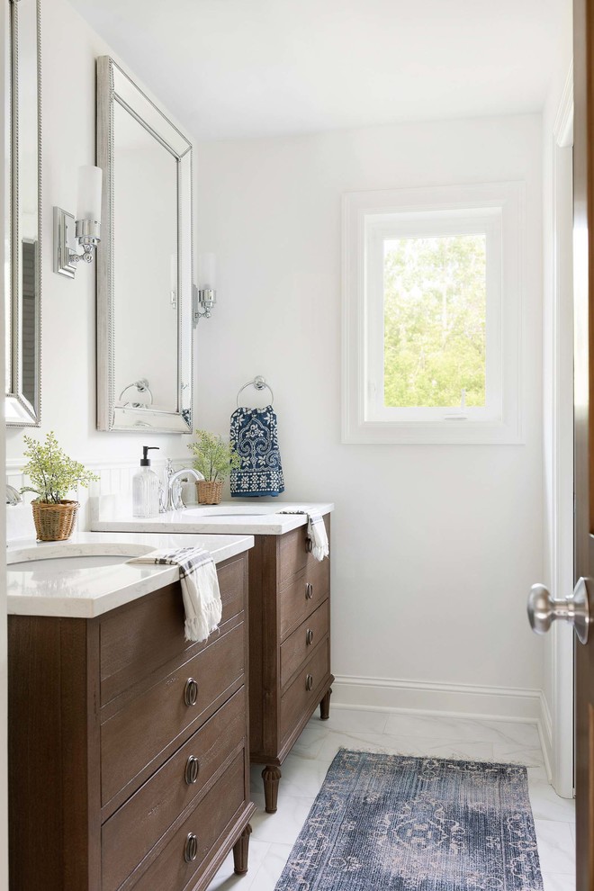 Classic ensuite bathroom in Minneapolis with white tiles, white walls, white worktops, dark wood cabinets, a submerged sink, white floors and flat-panel cabinets.
