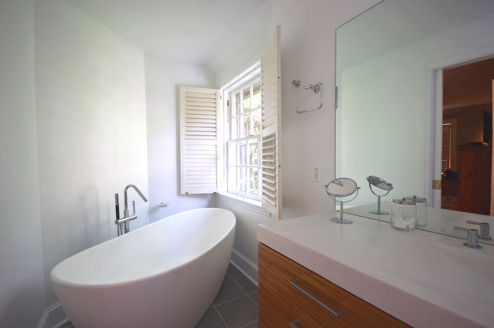 Cette photo montre une petite salle de bain principale tendance en bois clair avec un lavabo intégré, un placard à porte plane, un plan de toilette en béton, une baignoire indépendante, une douche double, WC à poser, un carrelage gris, des carreaux de céramique, un mur blanc et un sol en carrelage de céramique.