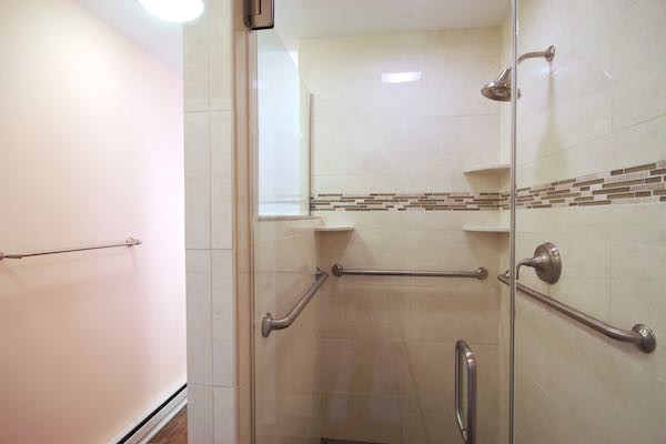 Ispirazione per una stanza da bagno padronale tradizionale di medie dimensioni con top in superficie solida, doccia alcova, piastrelle beige, piastrelle in ceramica, pareti rosa e pavimento con piastrelle in ceramica