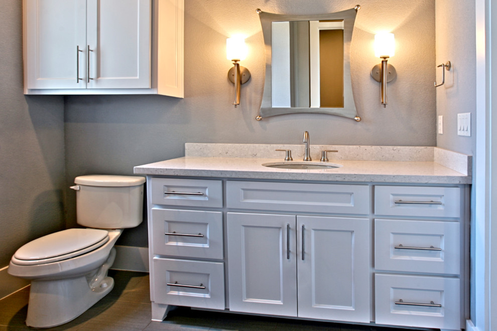 Small traditional shower room bathroom in Dallas with a built-in sink, raised-panel cabinets, white cabinets, limestone worktops, a one-piece toilet, grey walls and ceramic flooring.
