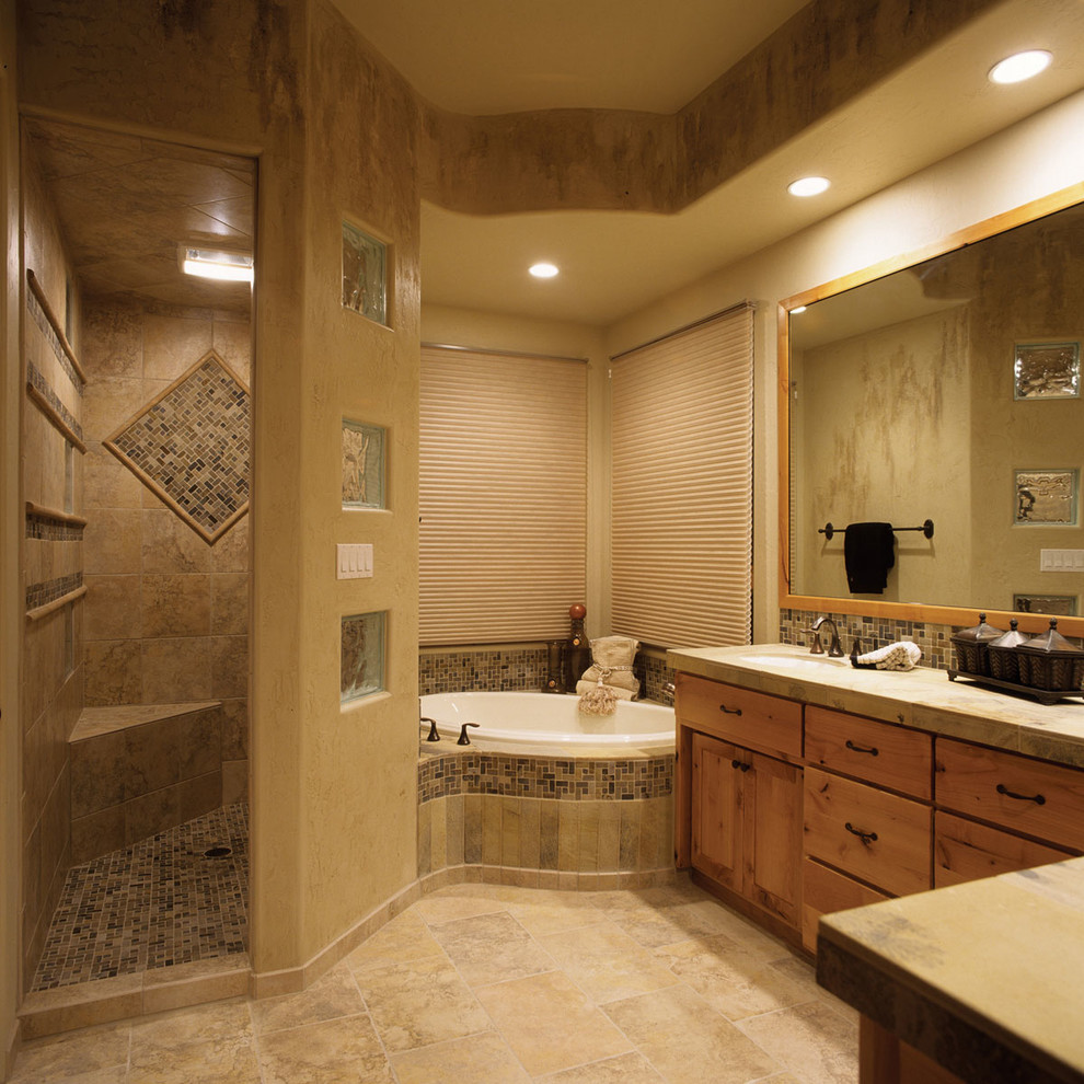 Photo of a large mediterranean ensuite bathroom in Denver with shaker cabinets, medium wood cabinets, a walk-in shower, beige tiles, brown tiles, mosaic tiles, beige walls, ceramic flooring, a submerged sink and a built-in bath.