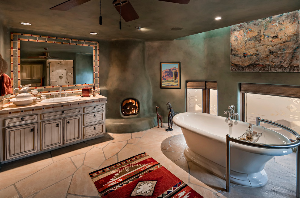 Mediterranes Duschbad mit Schrankfronten mit vertiefter Füllung, beigen Schränken, freistehender Badewanne, grüner Wandfarbe, Einbauwaschbecken, gefliestem Waschtisch und beigem Boden in Phoenix