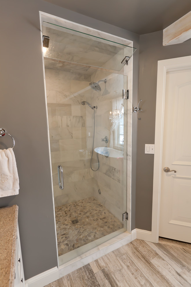 Idées déco pour une grande douche en alcôve principale classique avec des portes de placard blanches, une baignoire indépendante, un carrelage beige, des carreaux de porcelaine, un mur gris, un sol en vinyl et un lavabo encastré.