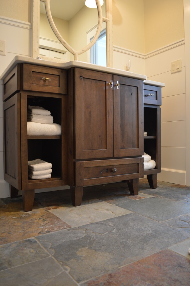 Foto de cuarto de baño rural de tamaño medio con armarios con paneles empotrados, puertas de armario de madera oscura, suelo de pizarra, aseo y ducha y encimera de cuarzo compacto