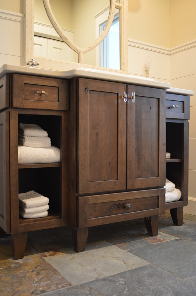 Imagen de cuarto de baño rural de tamaño medio con armarios con paneles empotrados, puertas de armario de madera oscura, suelo de pizarra, aseo y ducha y encimera de cuarzo compacto