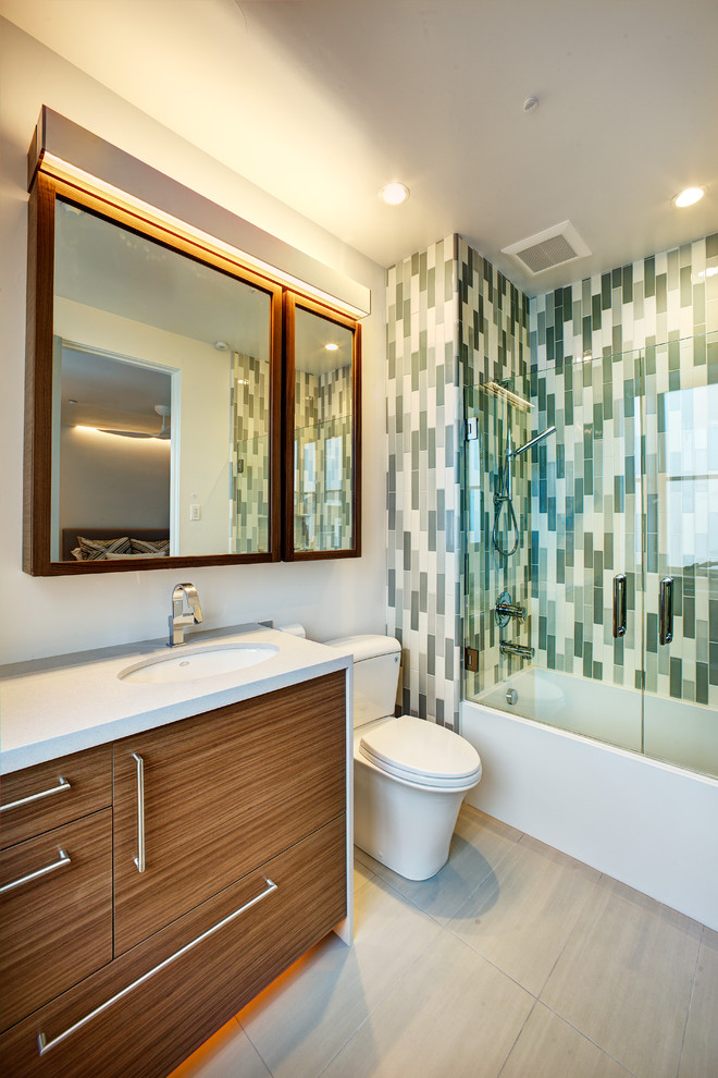 This is an example of a contemporary shower room bathroom in Sacramento with a submerged sink, flat-panel cabinets, dark wood cabinets, an alcove bath, a shower/bath combination, a two-piece toilet, green tiles, white walls, glass tiles, porcelain flooring, engineered stone worktops, grey floors and a hinged door.