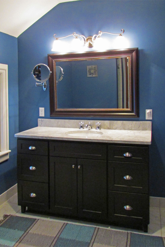 Foto de cuarto de baño tradicional de tamaño medio con armarios estilo shaker, puertas de armario negras, paredes azules, suelo de baldosas de cerámica, aseo y ducha, lavabo bajoencimera y encimera de mármol