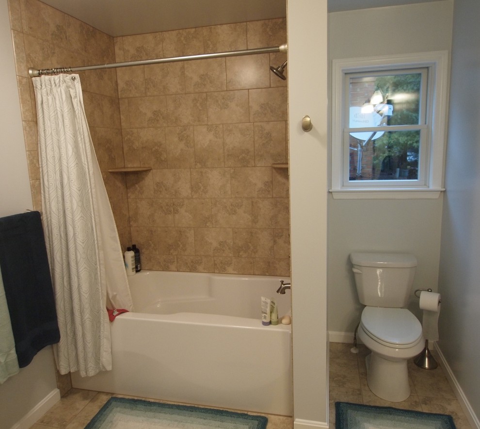 Example of a mid-sized classic master beige tile and ceramic tile ceramic tile bathroom design in Baltimore with raised-panel cabinets, medium tone wood cabinets, a two-piece toilet, beige walls, an undermount sink and solid surface countertops