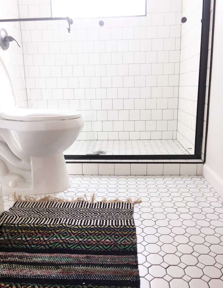 Foto på ett vintage badrum, med en dusch i en alkov, en toalettstol med hel cisternkåpa, vit kakel, keramikplattor, vita väggar, mosaikgolv, vitt golv och dusch med skjutdörr