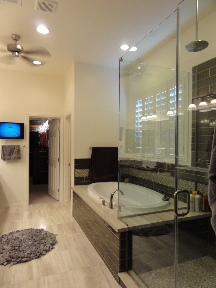 Cette photo montre une salle de bain tendance en bois foncé avec une vasque, un placard avec porte à panneau encastré, un plan de toilette en calcaire, une baignoire posée, une douche d'angle, WC séparés, un carrelage gris et un carrelage métro.