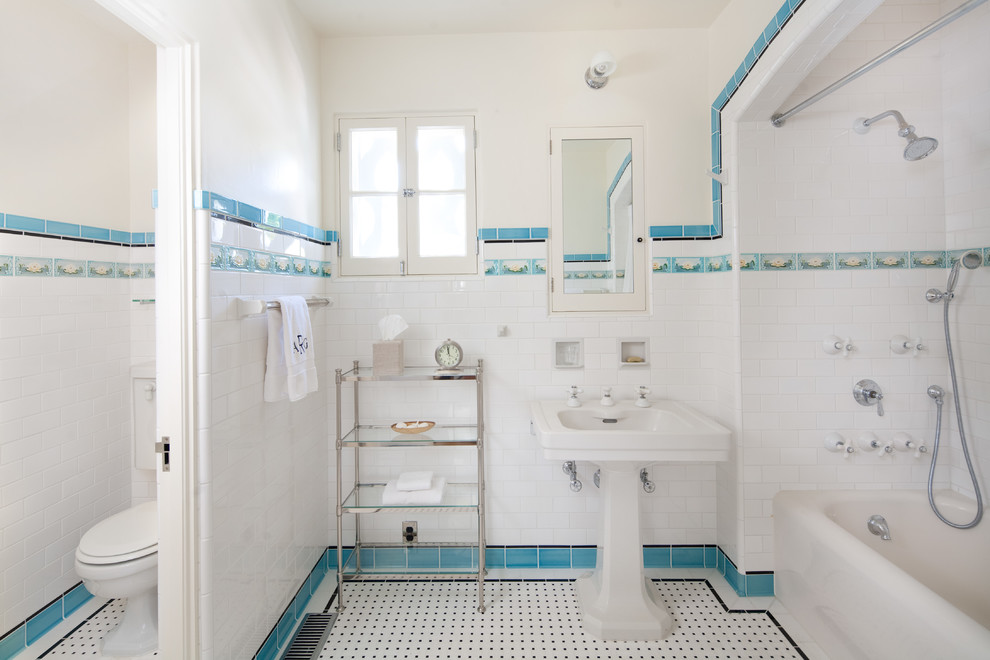 Medelhavsstil inredning av ett badrum, med ett piedestal handfat, ett badkar i en alkov, en dusch/badkar-kombination, vit kakel, tunnelbanekakel och vita väggar