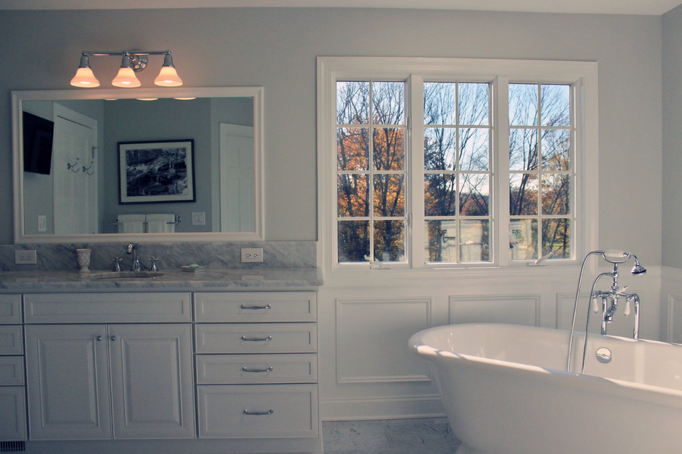 Idéer för ett stort klassiskt en-suite badrum, med luckor med infälld panel, vita skåp, ett fristående badkar, en hörndusch, en toalettstol med separat cisternkåpa, vit kakel, grå väggar, marmorgolv, ett undermonterad handfat och marmorbänkskiva