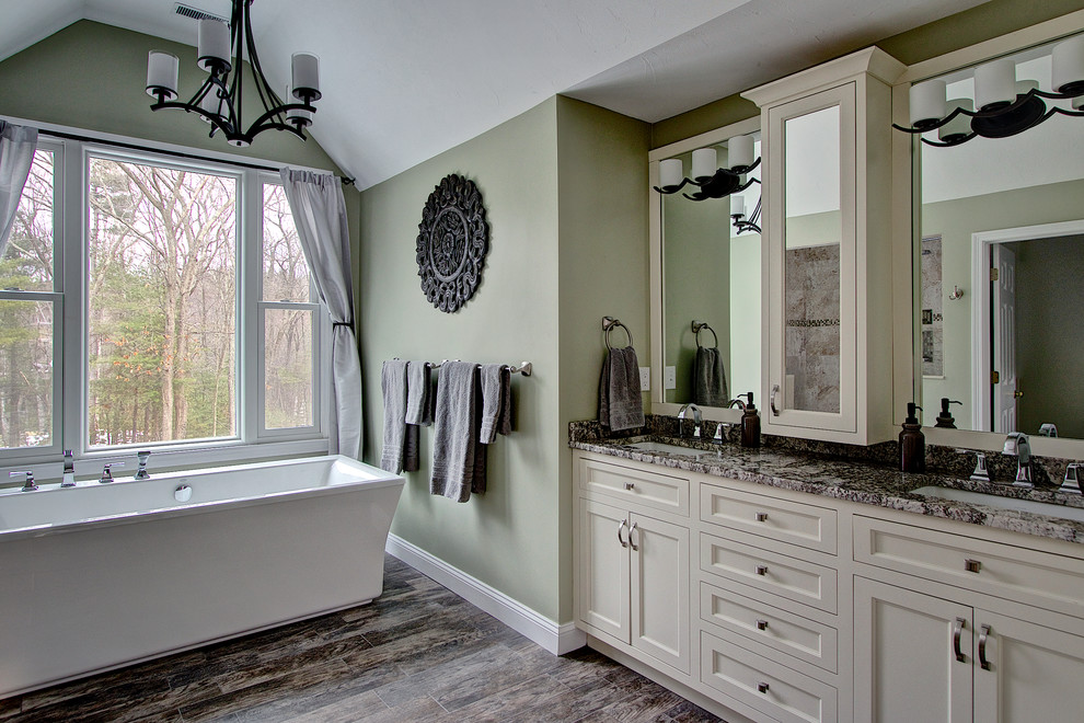 Klassisk inredning av ett mellanstort en-suite badrum, med skåp i shakerstil, vita skåp, ett fristående badkar, en dusch i en alkov, beige kakel, porslinskakel, gröna väggar, klinkergolv i porslin, ett undermonterad handfat, granitbänkskiva, grått golv och med dusch som är öppen