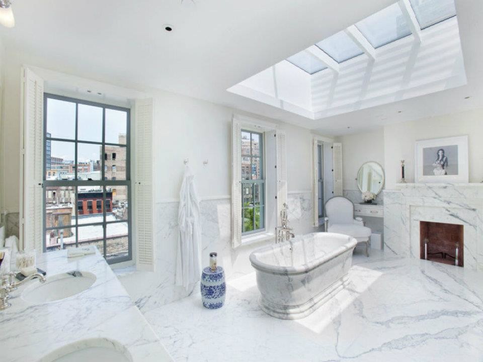 Foto på ett stort funkis en-suite badrum, med ett konsol handfat, luckor med profilerade fronter, vita skåp, marmorbänkskiva, ett fristående badkar, en hörndusch, en bidé, vit kakel, vita väggar och marmorgolv