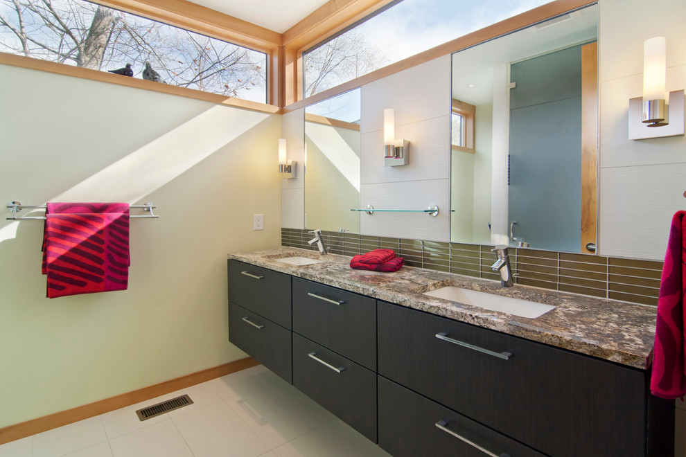 Modelo de cuarto de baño actual con lavabo bajoencimera, armarios con paneles lisos, puertas de armario de madera en tonos medios, baldosas y/o azulejos marrones y azulejos en listel