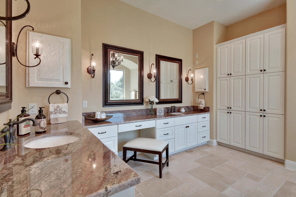 Design ideas for a large traditional ensuite bathroom in Austin with white cabinets, a freestanding bath, a double shower, a one-piece toilet, beige tiles, stone tiles, beige walls, travertine flooring, a submerged sink, granite worktops and raised-panel cabinets.