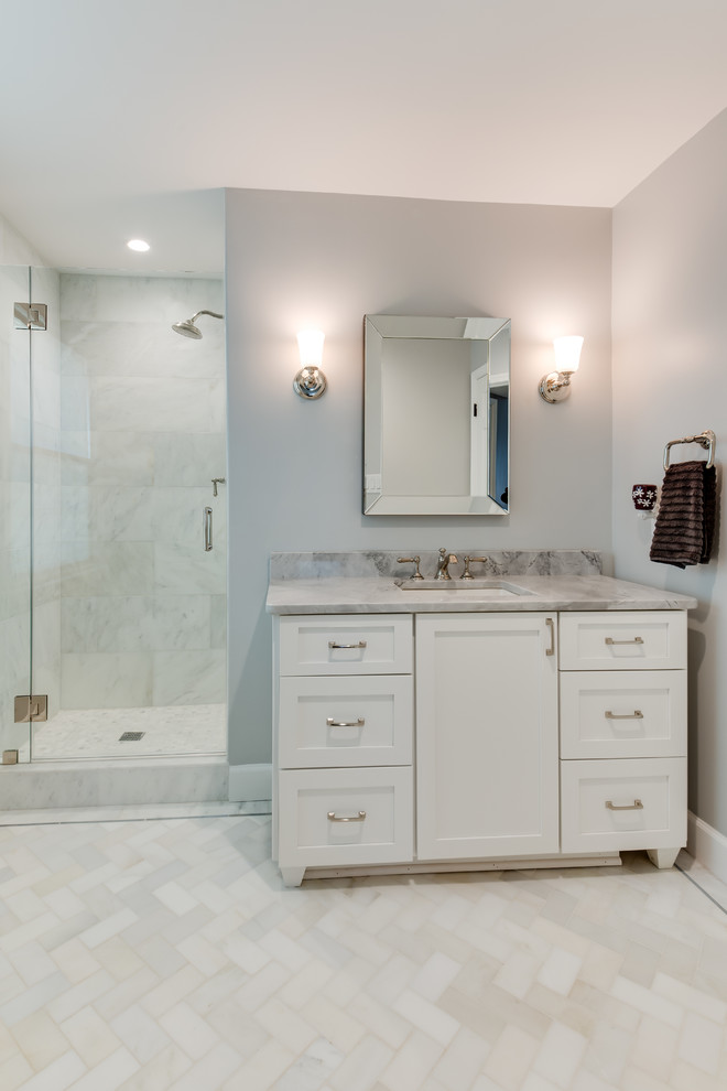 Inspiration for a large transitional 3/4 marble tile porcelain tile and brown floor bathroom remodel in Other with shaker cabinets, white cabinets, a two-piece toilet, gray walls, an undermount sink, marble countertops and a hinged shower door