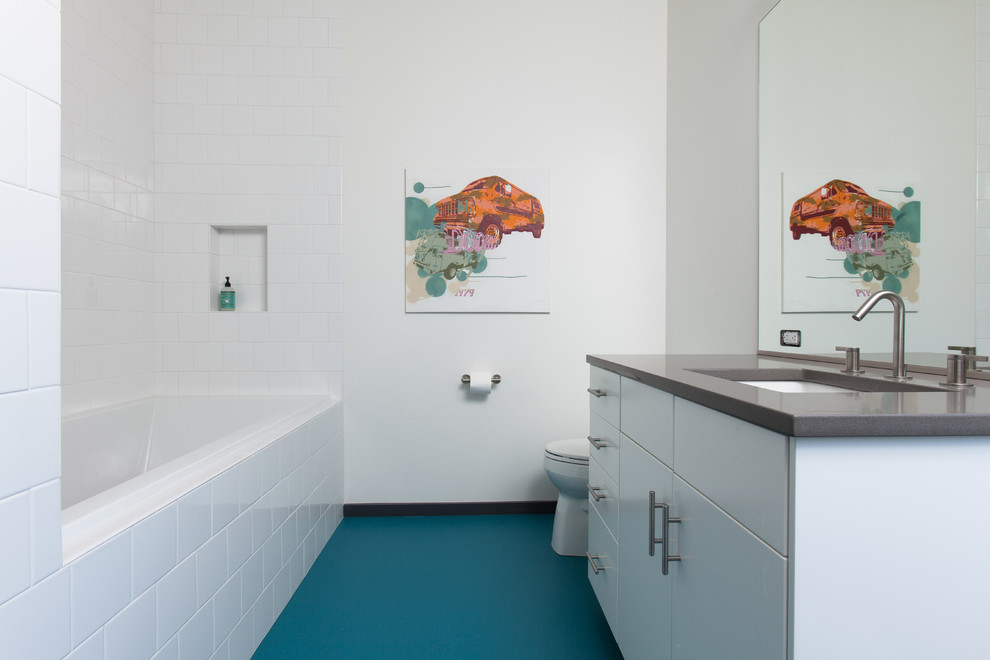 Idée de décoration pour une grande salle de bain minimaliste pour enfant avec un lavabo encastré, un placard à porte plane, des portes de placard blanches, une baignoire posée, une douche d'angle, WC à poser, un carrelage blanc, des carreaux de céramique, un mur blanc, un sol en linoléum et un sol bleu.