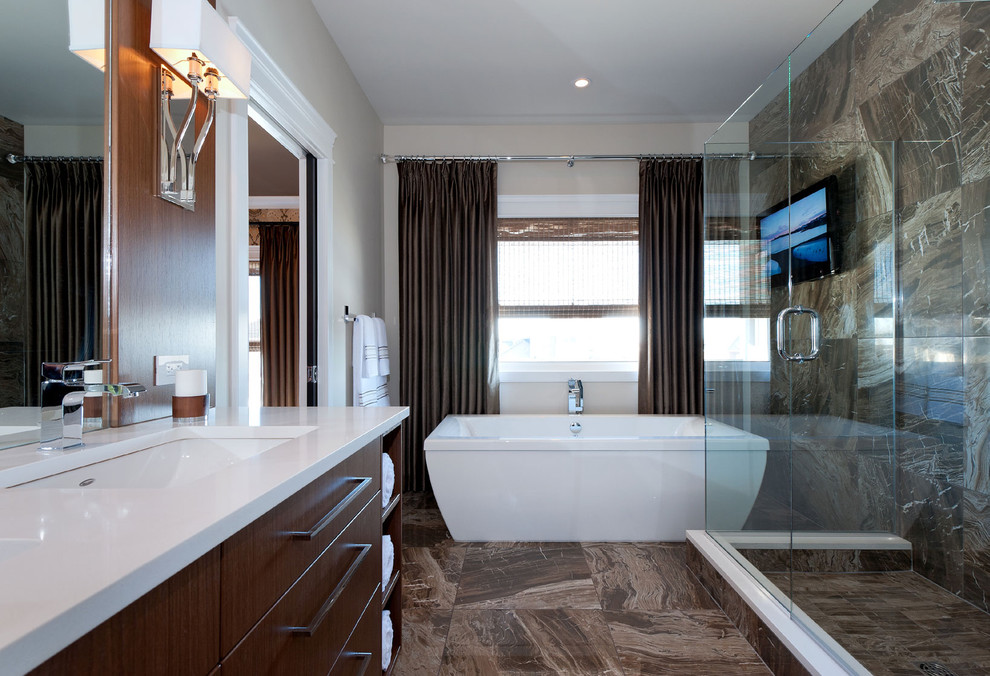 Modernes Badezimmer mit flächenbündigen Schrankfronten, dunklen Holzschränken, freistehender Badewanne und weißer Waschtischplatte in Sonstige