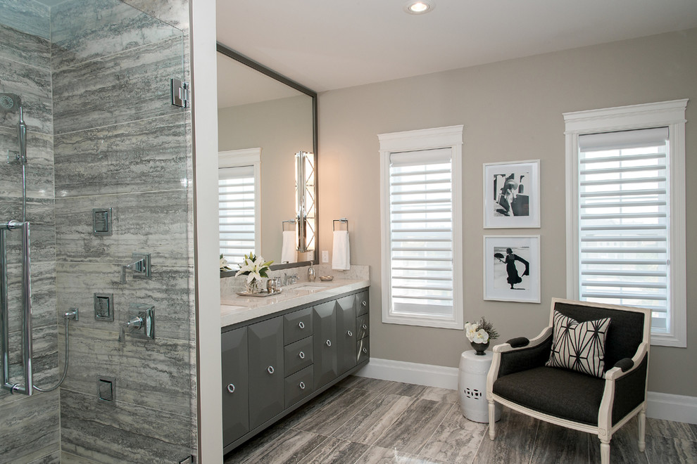 Immagine di una stanza da bagno contemporanea con lavabo sottopiano, ante con bugna sagomata, ante grigie e piastrelle grigie