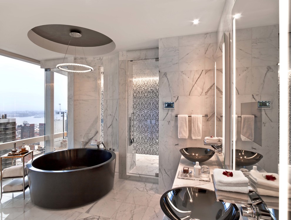Ejemplo de cuarto de baño contemporáneo con lavabo sobreencimera, bañera exenta y suelo de mármol