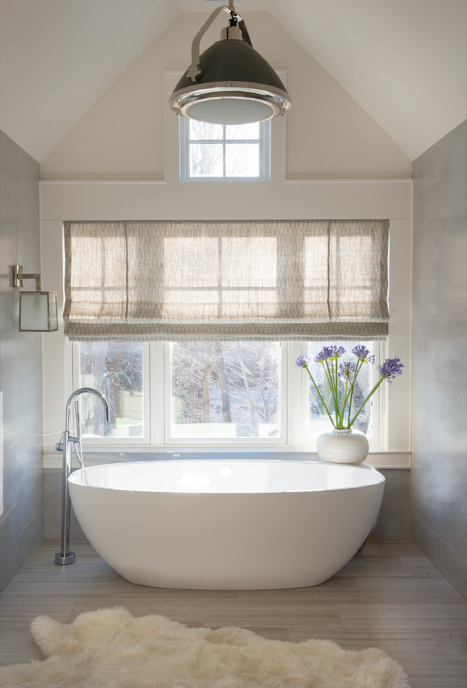 Modelo de cuarto de baño principal clásico renovado pequeño con bañera exenta, paredes grises, suelo de baldosas de porcelana y suelo beige