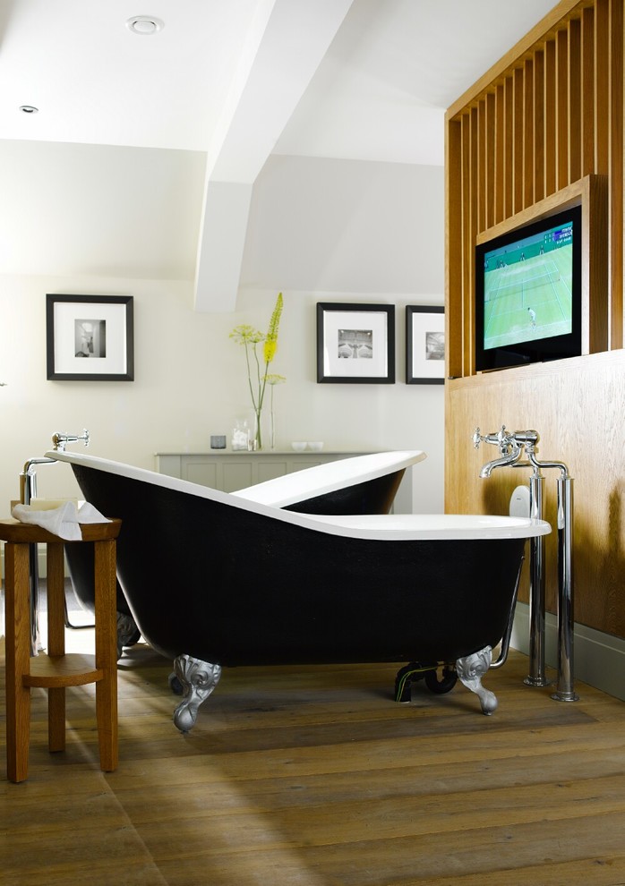 Mid-sized trendy master black tile and ceramic tile light wood floor claw-foot bathtub photo in London with furniture-like cabinets, gray cabinets and white walls