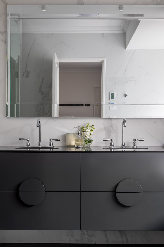 Example of a mid-sized 1950s master porcelain tile black floor and double-sink freestanding bathtub design in Perth with black cabinets, a one-piece toilet, an undermount sink, tile countertops, black countertops and a floating vanity