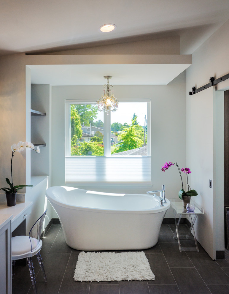 Пример оригинального дизайна: главная ванная комната среднего размера в современном стиле с фасадами с филенкой типа жалюзи, серыми фасадами, отдельно стоящей ванной, белыми стенами, полом из керамической плитки, черным полом и белой столешницей