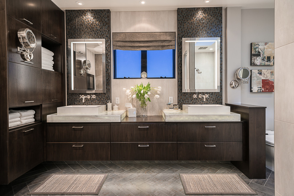 На фото: ванная комната в современном стиле с настольной раковиной, плоскими фасадами, темными деревянными фасадами, плиткой мозаикой, серыми стенами и зеркалом с подсветкой с