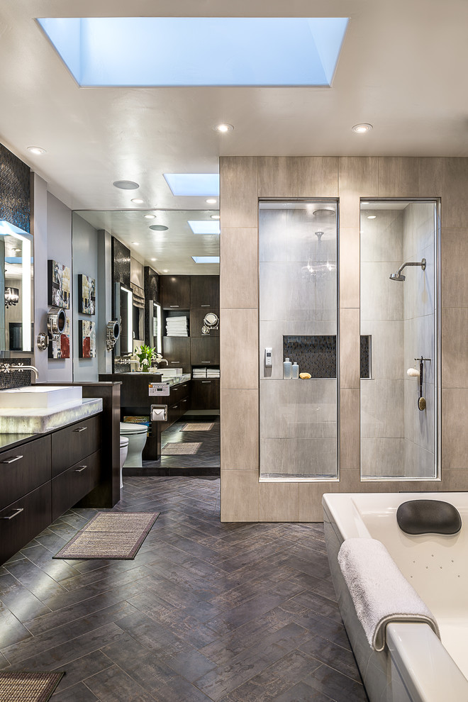 サンフランシスコにあるコンテンポラリースタイルのおしゃれなマスターバスルーム (ベッセル式洗面器、フラットパネル扉のキャビネット、濃色木目調キャビネット、置き型浴槽、グレーのタイル) の写真
