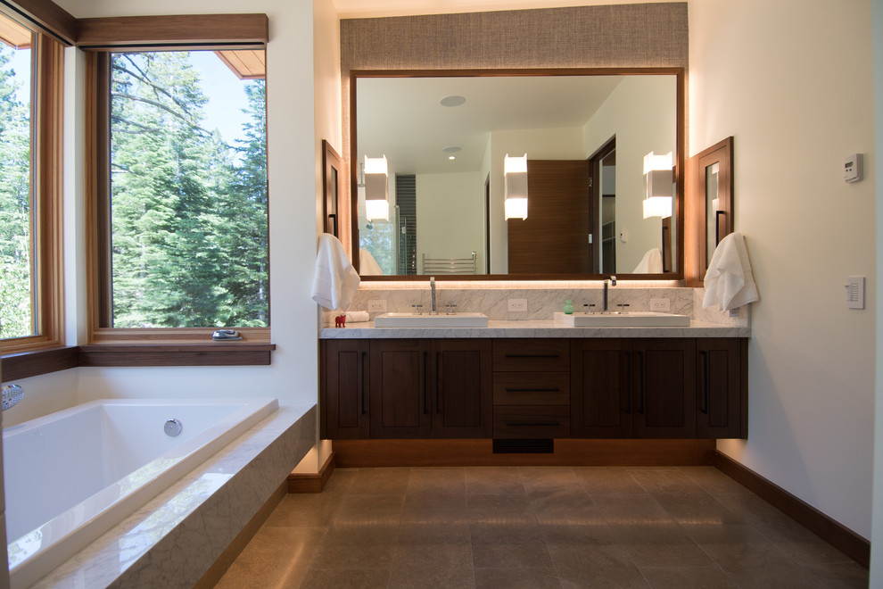 Mid-sized minimalist master limestone floor and brown floor bathroom photo in Sacramento with flat-panel cabinets, dark wood cabinets, a one-piece toilet, white walls, a drop-in sink, marble countertops, a hinged shower door and yellow countertops