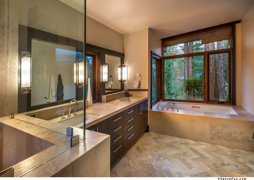Example of a large transitional master beige tile and stone tile limestone floor corner shower design in Sacramento with an undermount sink, flat-panel cabinets, dark wood cabinets, limestone countertops, an undermount tub, a bidet and beige walls