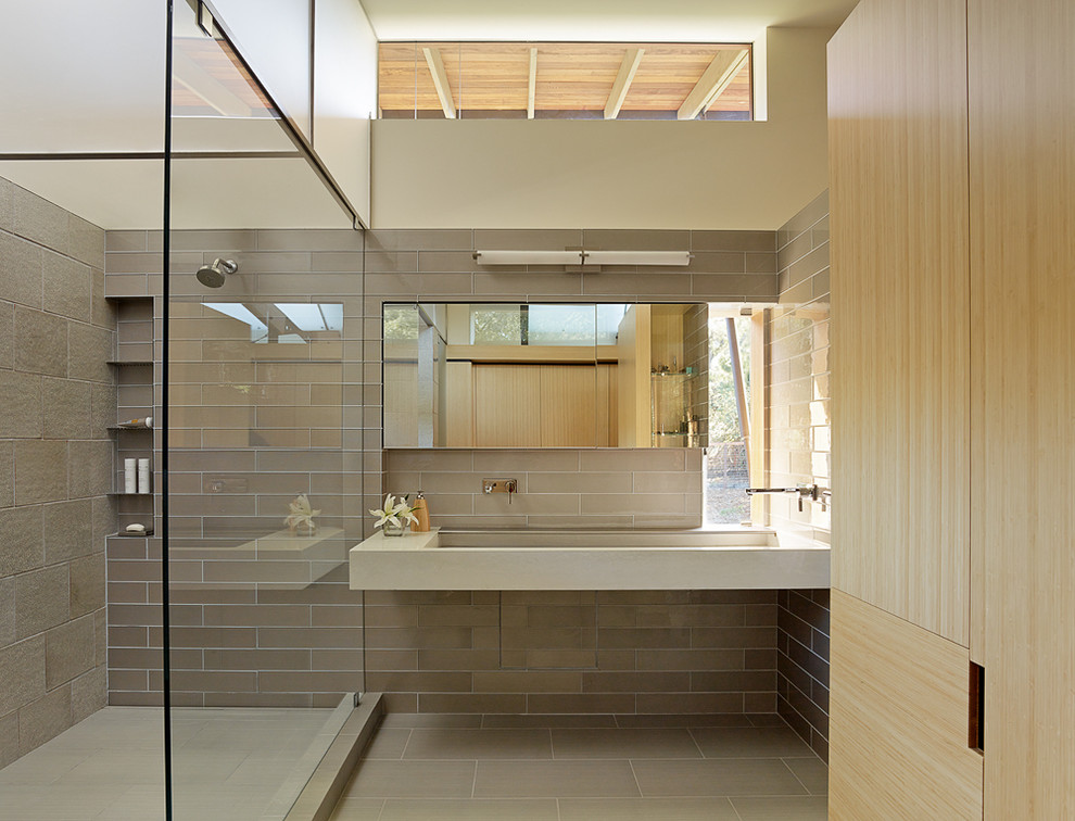 Large contemporary shower room bathroom in San Francisco with flat-panel cabinets, light wood cabinets, a corner shower, brown tiles, a trough sink, an open shower, grey walls, concrete worktops, grey floors and grey worktops.
