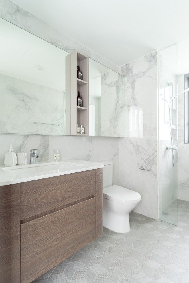 Réalisation d'une douche en alcôve design en bois brun avec un placard à porte plane, un lavabo encastré, un sol gris et un plan de toilette blanc.