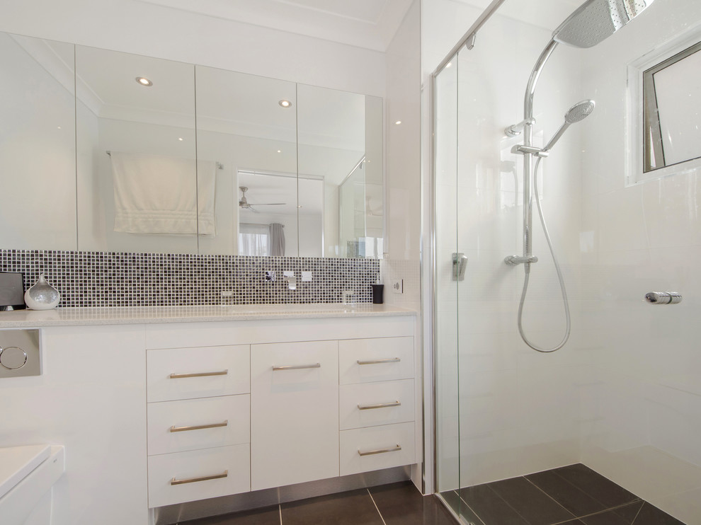 На фото: ванная комната среднего размера в современном стиле с плоскими фасадами, белыми фасадами, душем в нише, унитазом-моноблоком, белой плиткой, белыми стенами, душевой кабиной и врезной раковиной