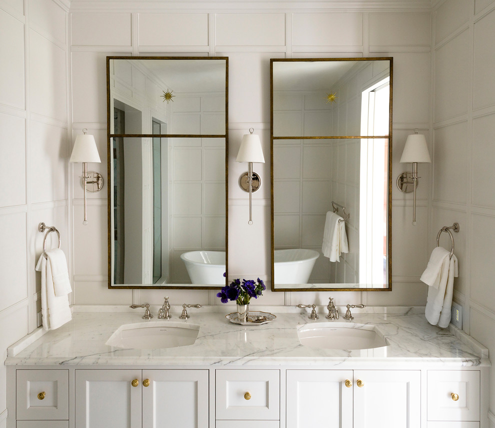Foto de cuarto de baño principal tradicional grande con armarios con paneles empotrados, puertas de armario blancas, bañera exenta, paredes blancas y lavabo bajoencimera