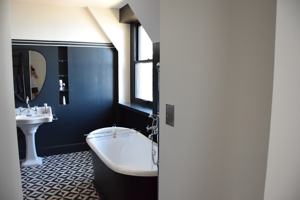 Medium sized bohemian ensuite bathroom in London with a freestanding bath, a walk-in shower, black and white tiles, cement tiles, blue walls and a pedestal sink.