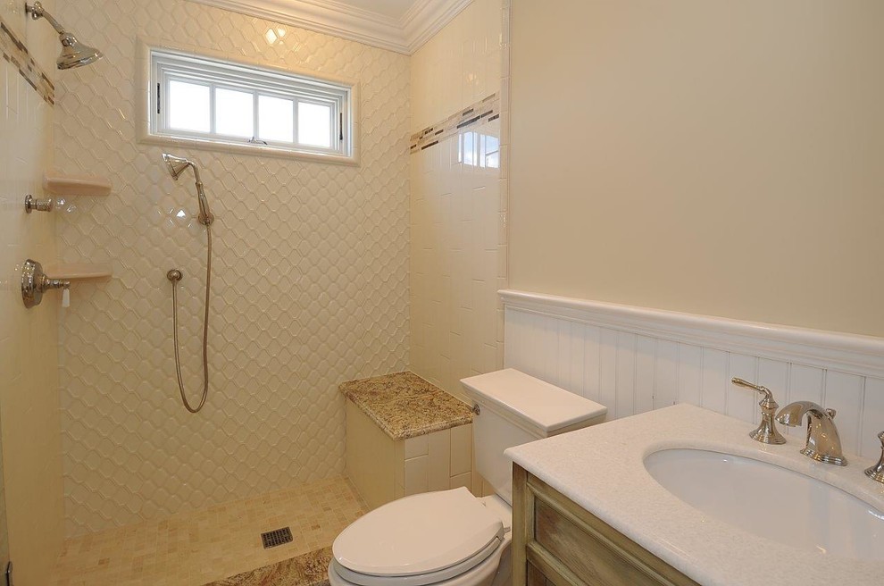 Klassisk inredning av ett mellanstort brun brunt badrum, med luckor med upphöjd panel, bruna skåp, en öppen dusch, en toalettstol med hel cisternkåpa, vit kakel, keramikplattor, gula väggar, klinkergolv i porslin, ett undermonterad handfat, granitbänkskiva, vitt golv och med dusch som är öppen