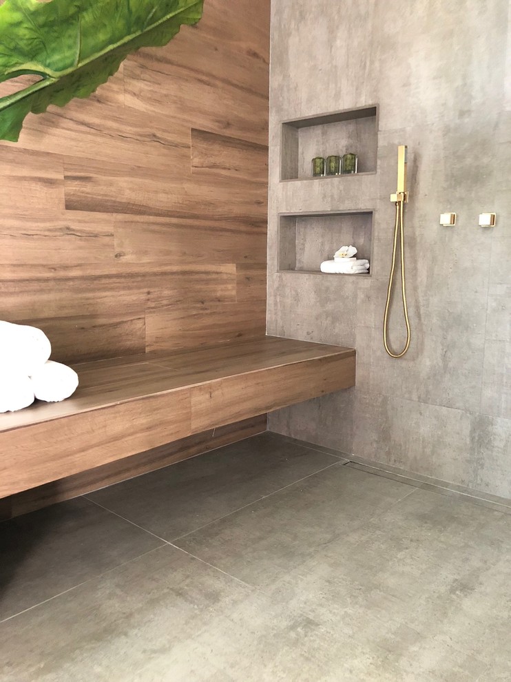 Cette photo montre une salle de bain exotique de taille moyenne avec une douche ouverte, un carrelage gris, des carreaux de porcelaine, un mur gris et aucune cabine.