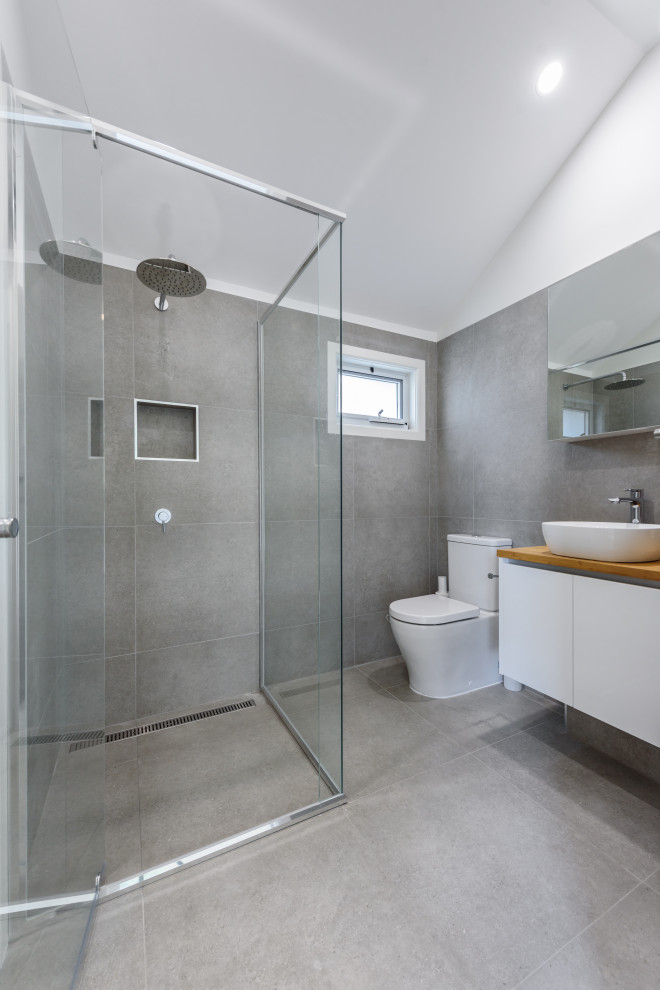 Exempel på ett litet modernt badrum, med vita skåp, grå kakel, keramikplattor, klinkergolv i keramik, träbänkskiva och grått golv