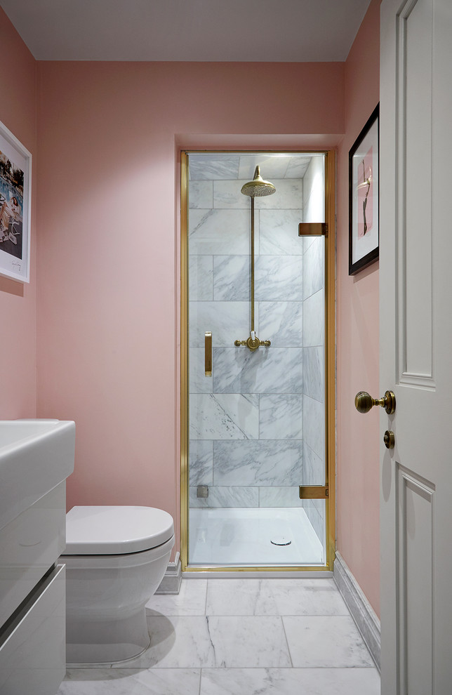 Réalisation d'une petite salle de bain grise et rose minimaliste avec un placard à porte plane, des portes de placard blanches, une douche ouverte, WC à poser, du carrelage en marbre, un mur rose, un sol blanc et une cabine de douche à porte battante.