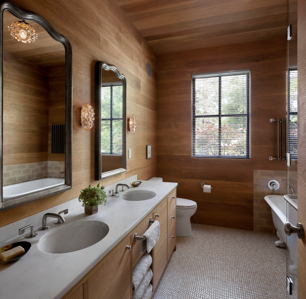 Idée de décoration pour une salle de bain design en bois clair avec un placard à porte plane, une baignoire sur pieds, un sol en carrelage de céramique, un plan de toilette en marbre et un lavabo encastré.