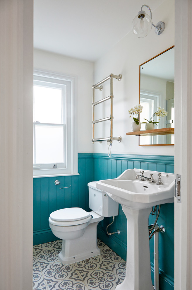 Immagine di una stanza da bagno con doccia classica con WC a due pezzi, lavabo a colonna e pavimento multicolore